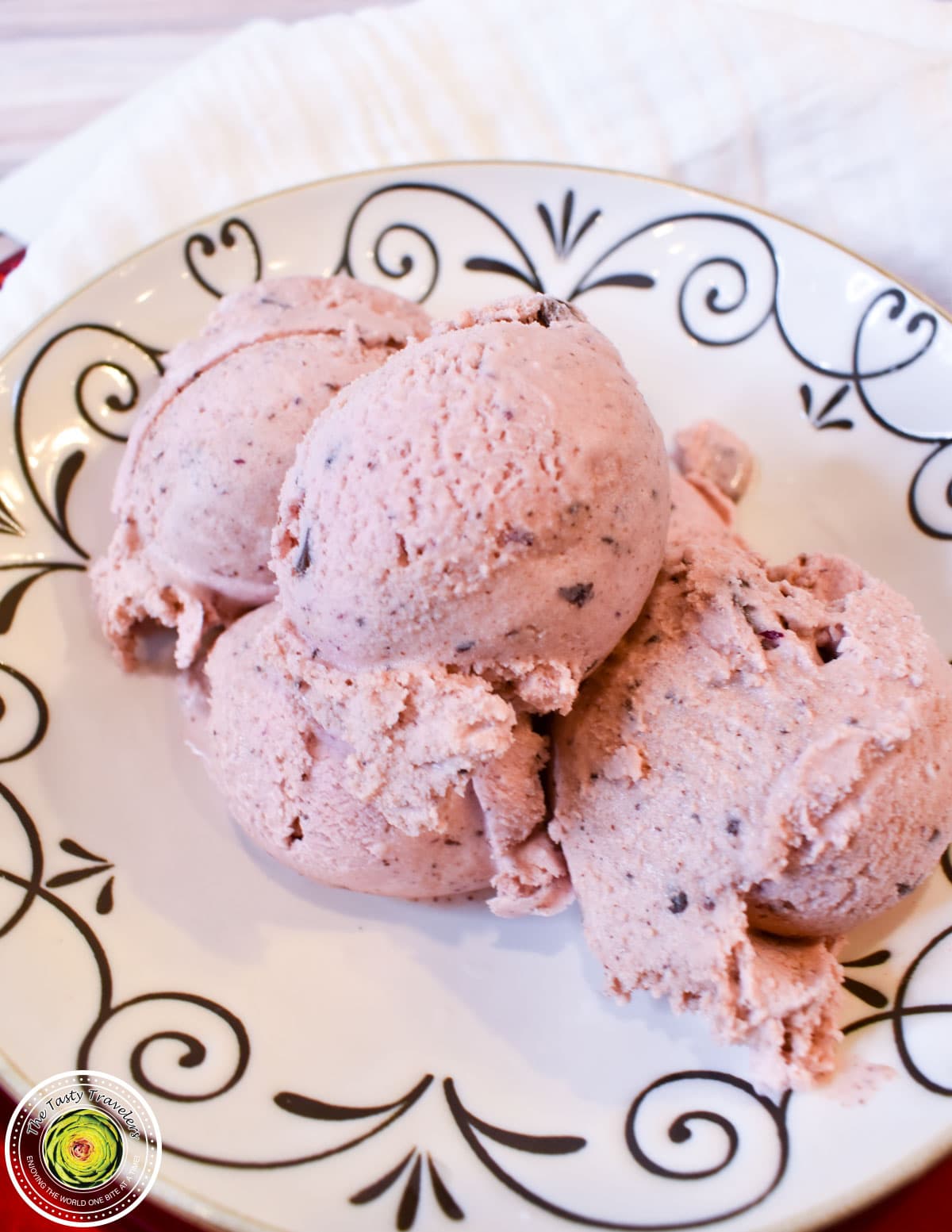 Ninja Creami black cherry chocolate chunk ice cream in a pint container with fresh cherries and chocolate chunks on top