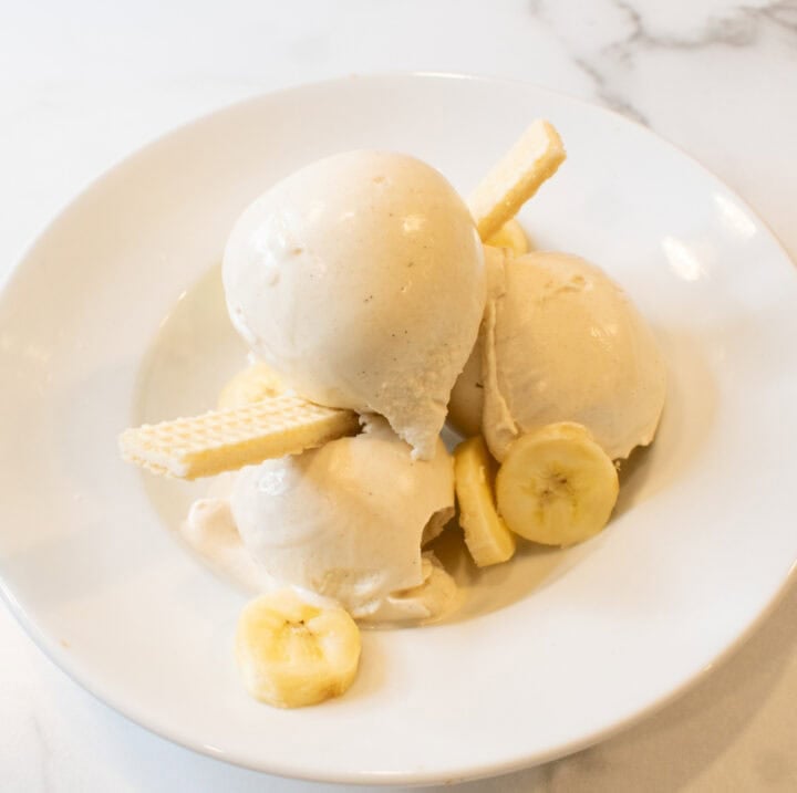 Delicious banana pudding ice cream topped with banana slices and crispy wafers, perfect for a sweet.