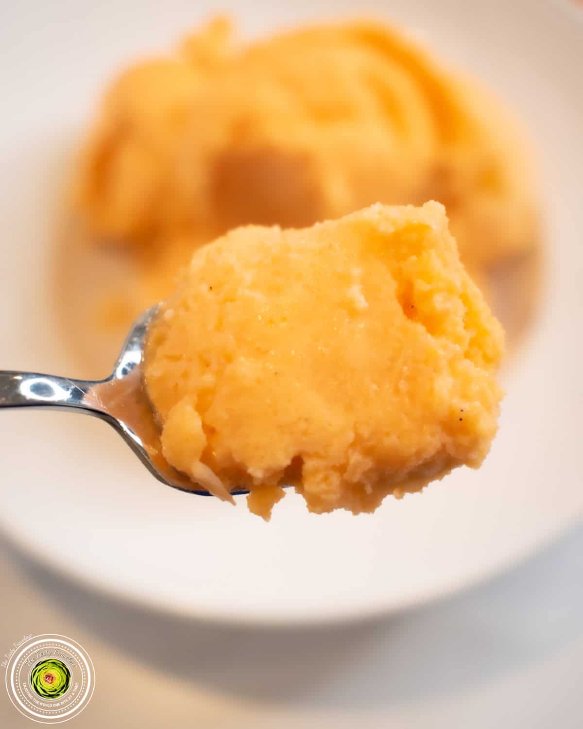 Ninja Creami Orange Creamsicle Protein Ice Cream scooped into a bowl showing the light orange color