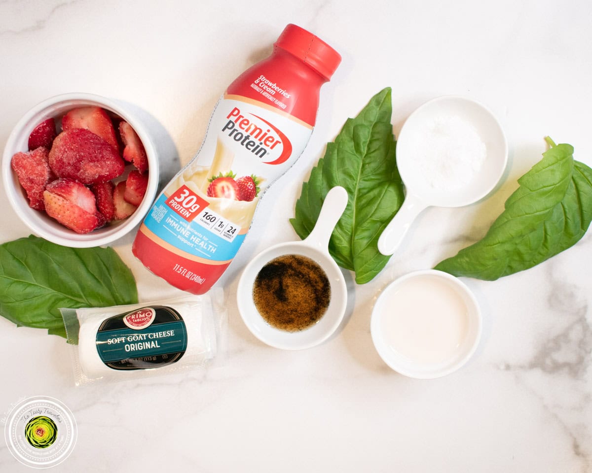 Ingredients for Ninja Creami strawberry basil goat cheese protein ice cream including strawberries, strawberry protein shake, fresh basil, and goat cheese