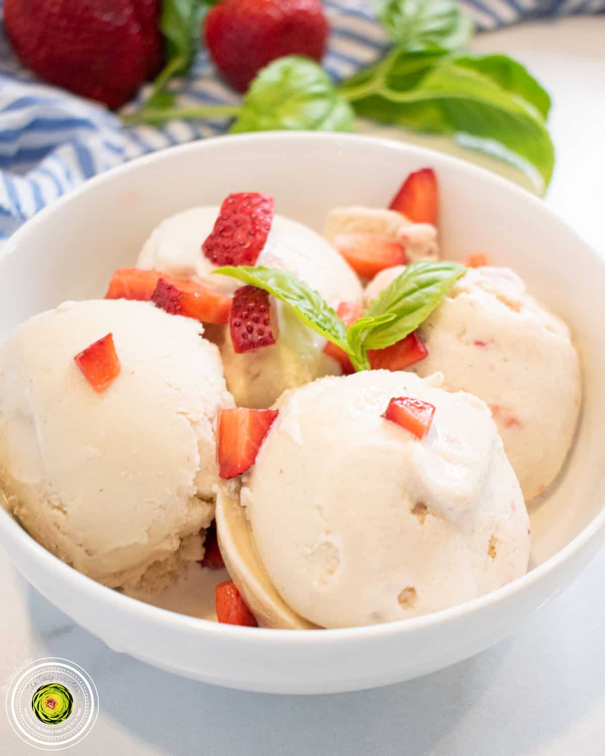 Ninja Creami strawberry basil goat cheese protein ice cream in a pint container with fresh strawberries and basil on top