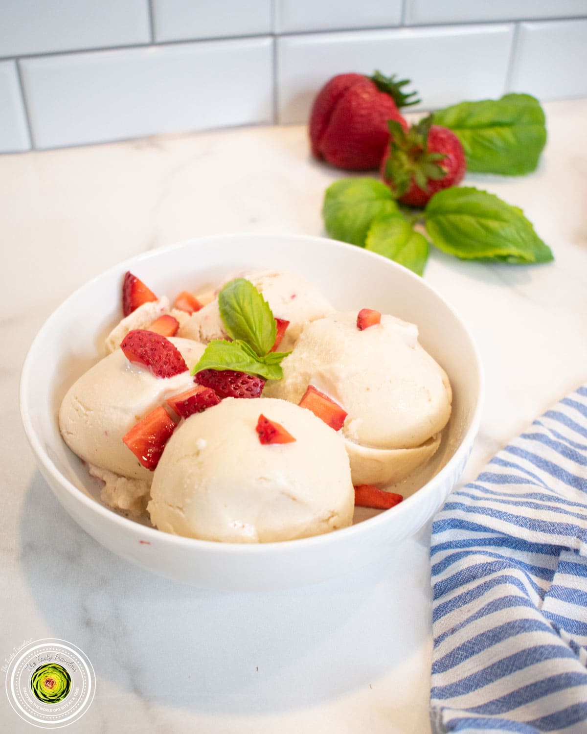 Bowl of Ninja Creami strawberry basil goat cheese protein ice cream topped with fresh strawberries and basil