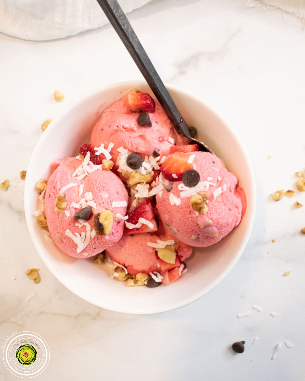 Ninja Creami strawberry coco-nut protein ice cream in a pint container with coconut and chocolate chips on top