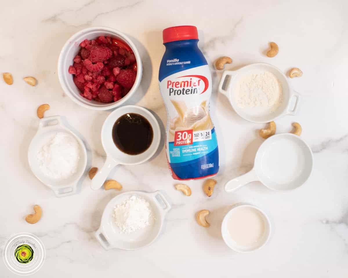Ingredients for Ninja Creami baseball nut protein ice cream including vanilla protein shake, raspberries, and cashews