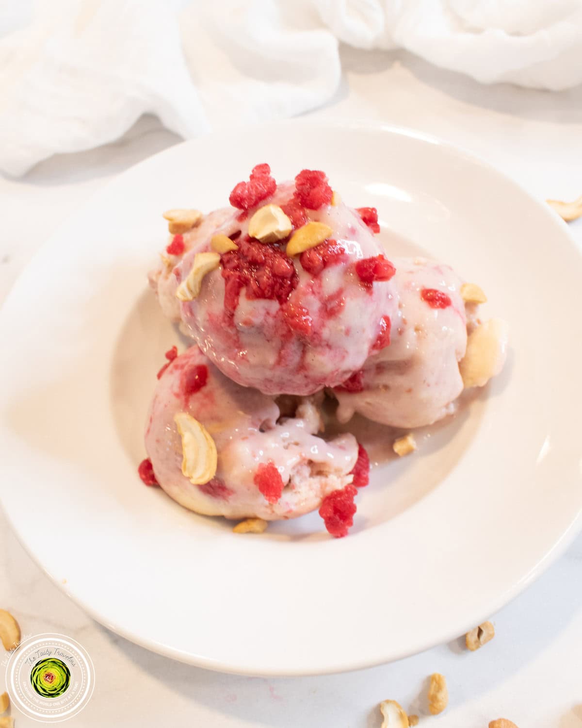 Scooped Ninja Creami baseball nut protein ice cream with visible cashews and raspberry sauce