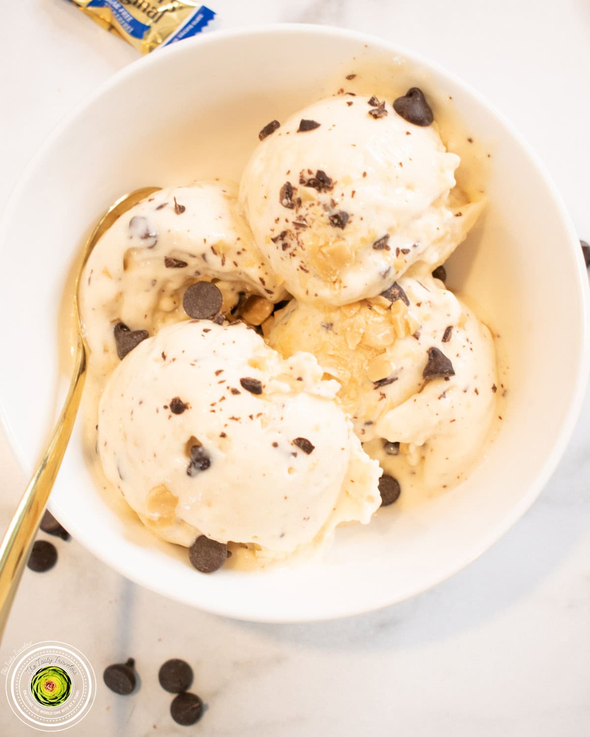 Ninja Creami caramel chocolate chip cheesecake protein ice cream in a pint container with chocolate chips and Werther's pieces on top