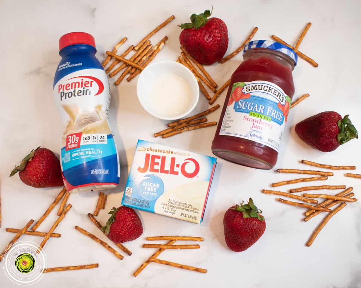 Ingredients for Ninja Creami strawberry pretzel pie protein ice cream including vanilla protein shake, cheesecake pudding mix, fresh strawberries, and pretzels