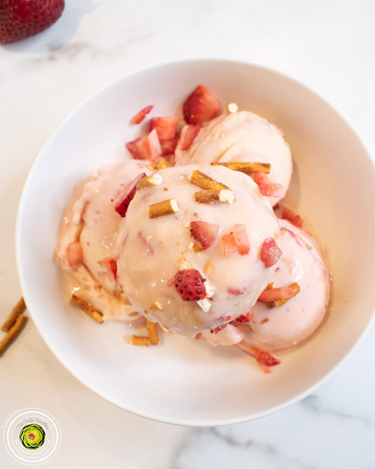 Ninja Creami strawberry pretzel pie protein ice cream in a pint container with strawberries and pretzels on top