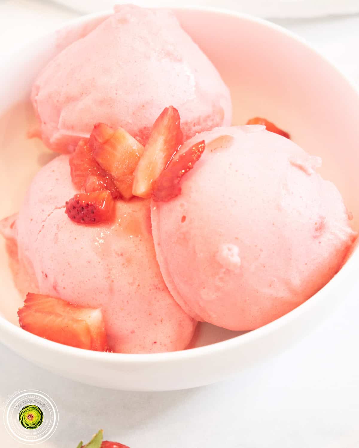 Ninja Creami super strawberry protein ice cream in a pint container with fresh strawberries on top