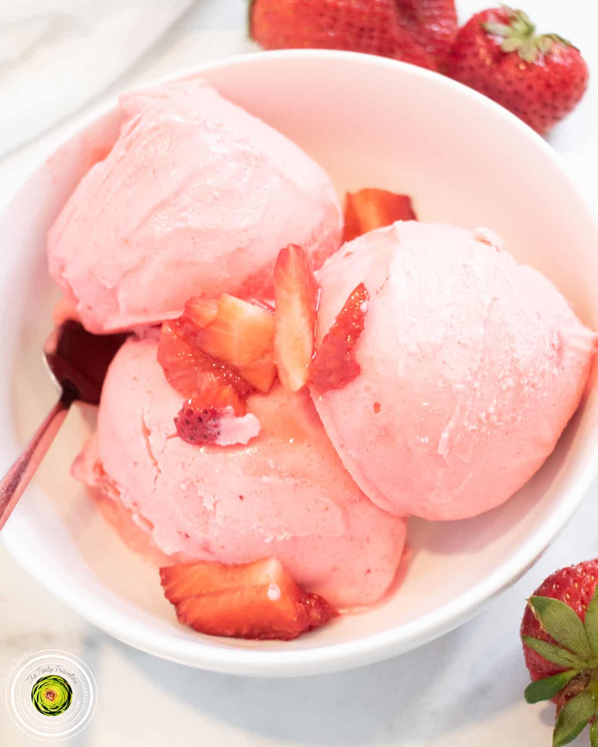 Bowl of Ninja Creami super strawberry protein ice cream topped with sliced strawberries