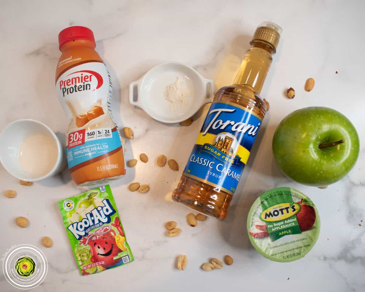 Ingredients for Ninja Creami taffy apple protein ice cream including caramel protein shake, applesauce, apple Kool-Aid, peanuts, and green apple