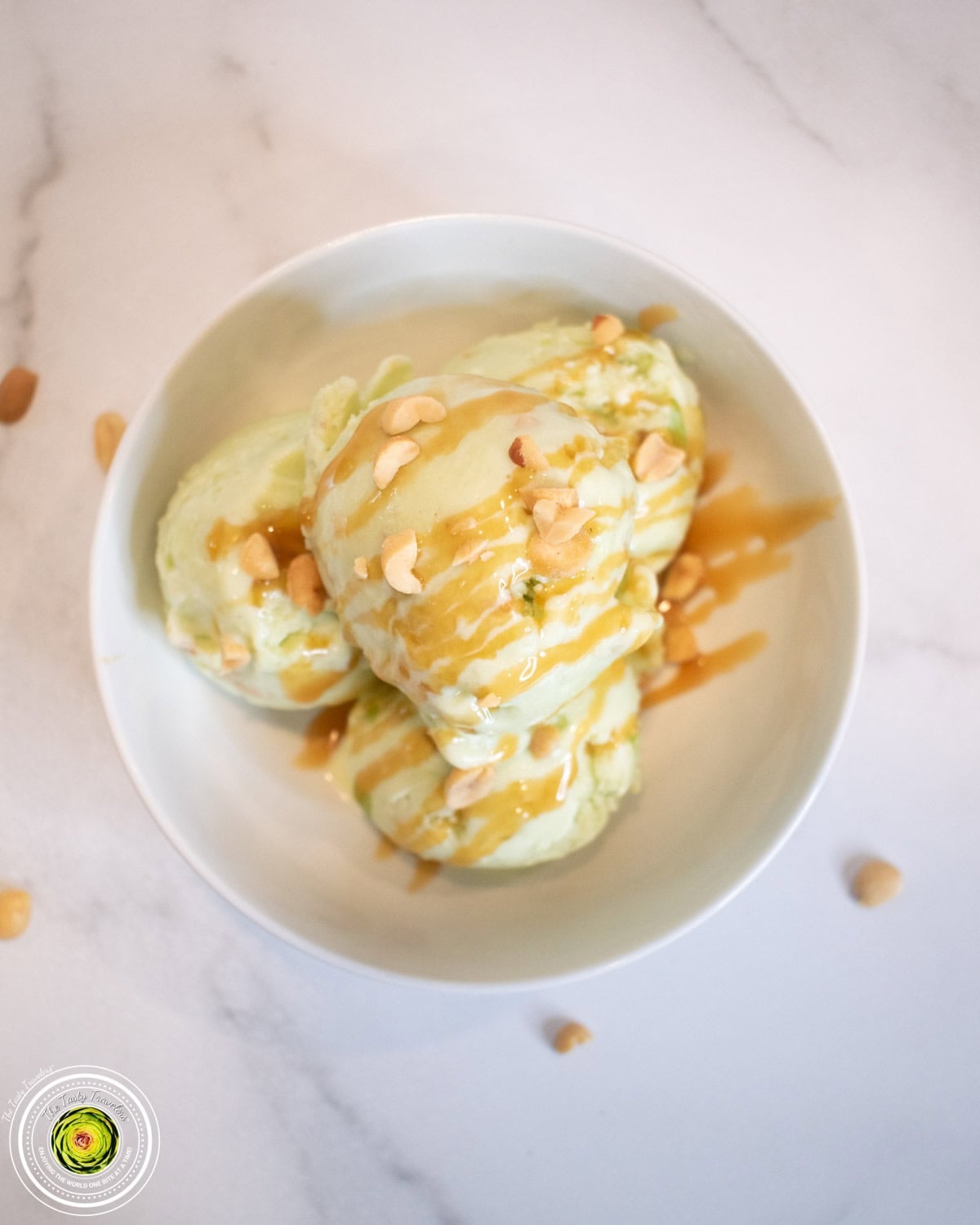 Bowl of Ninja Creami taffy apple protein ice cream topped with caramel syrup and peanuts