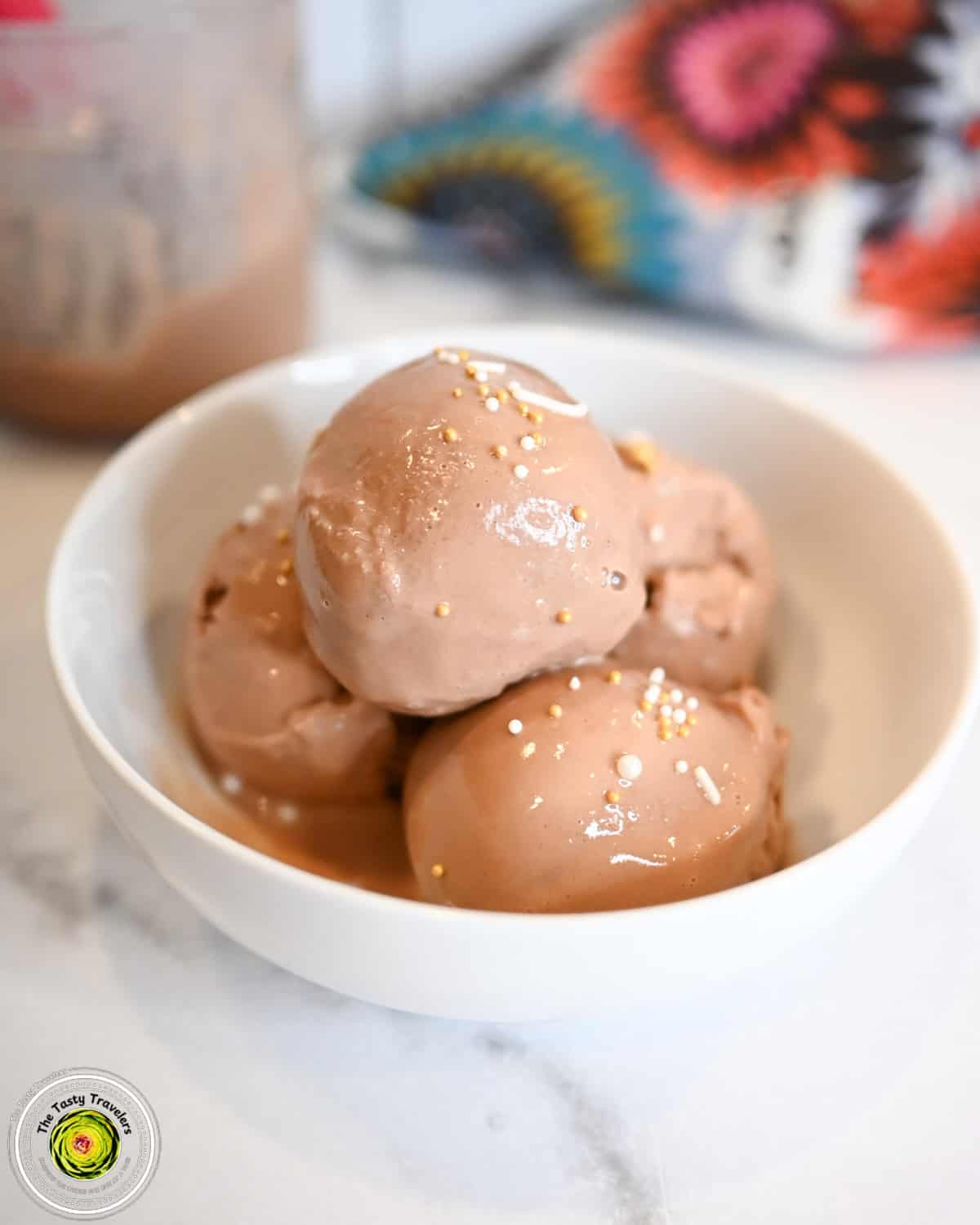 Bowl of Ninja Creami low calorie chocolate frozen yogurt topped with chocolate sauce