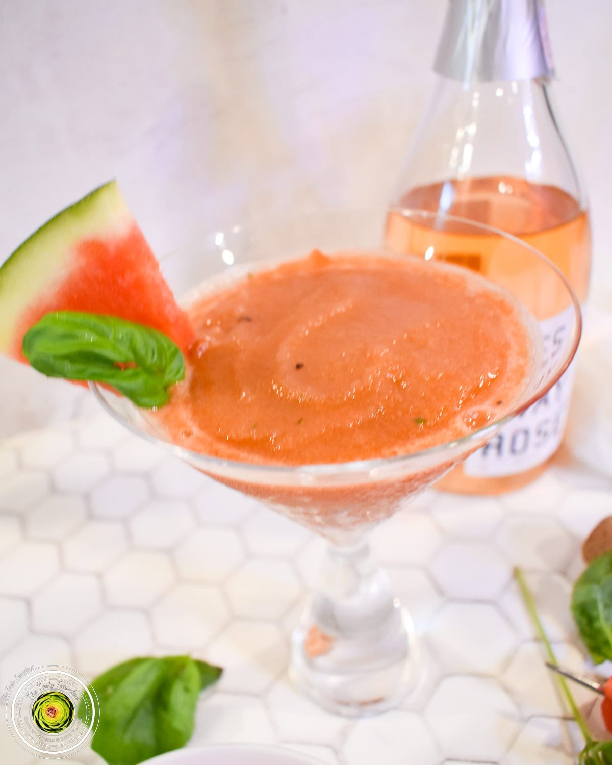 Ninja Creami watermelon basil frosé in a glass with fresh watermelon and basil garnish