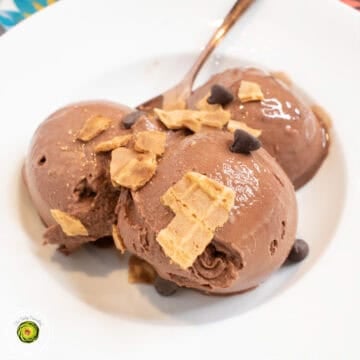 Creamy chocolate ice cream scoops topped with cereal flakes and chocolate chips.