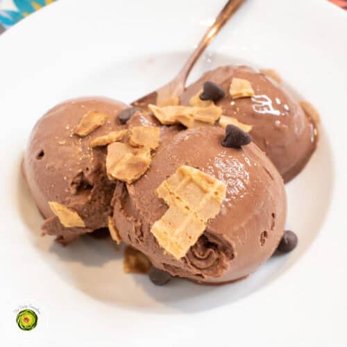 Creamy chocolate ice cream scoops topped with cereal flakes and chocolate chips.