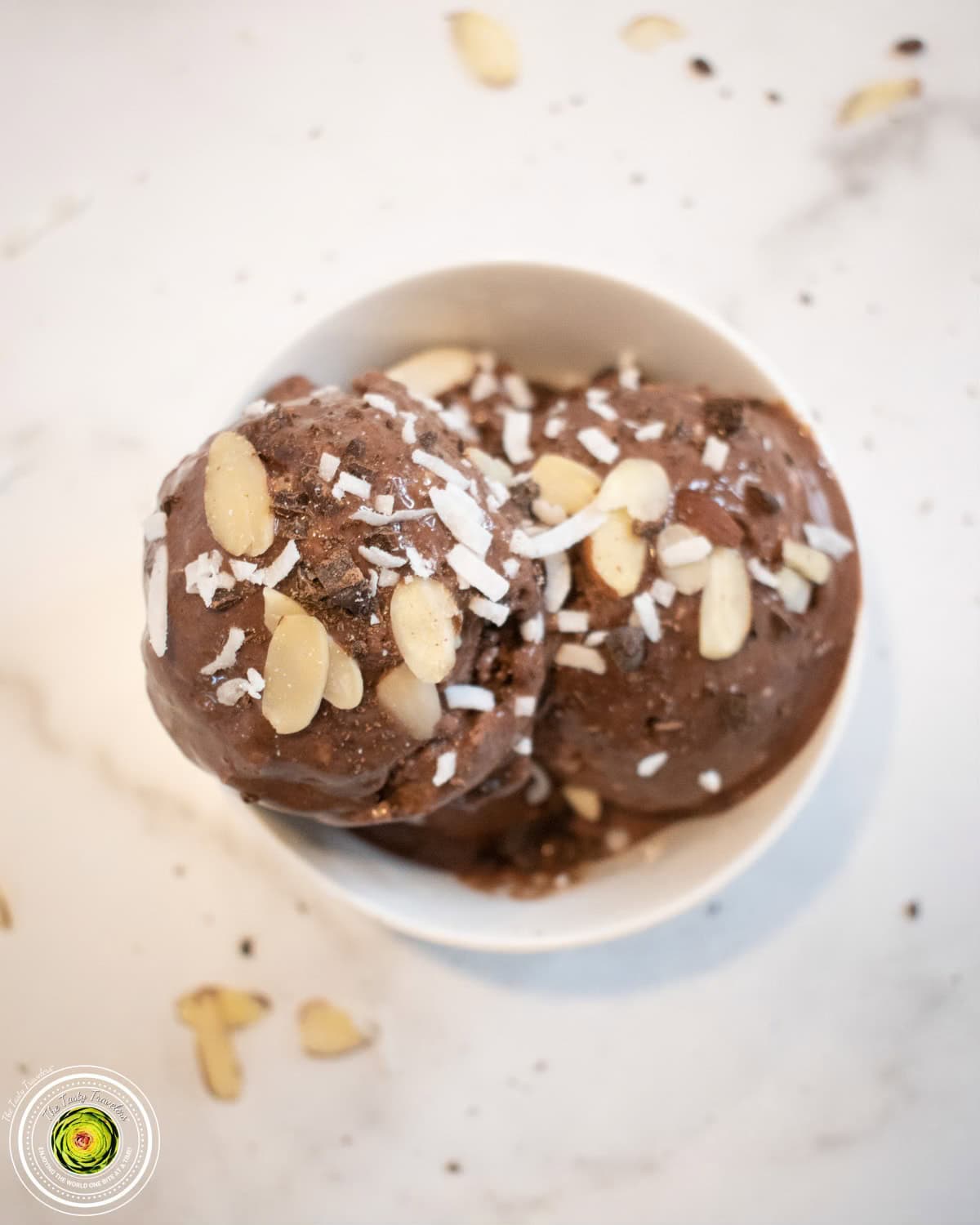 Ninja Creami Almond Joy Protein Ice Cream scooped into a bowl with coconut, almonds, and chocolate chips visible