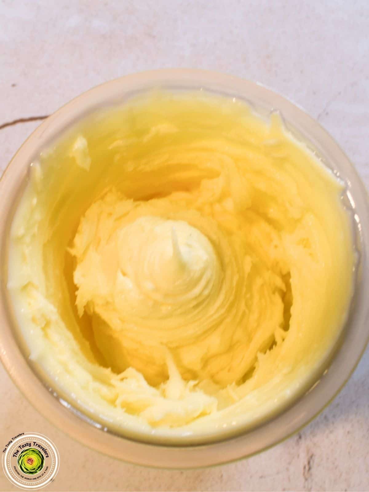Ninja Creami lemon ice cream in a bowl topped with lemon zest and a slice of fresh lemon