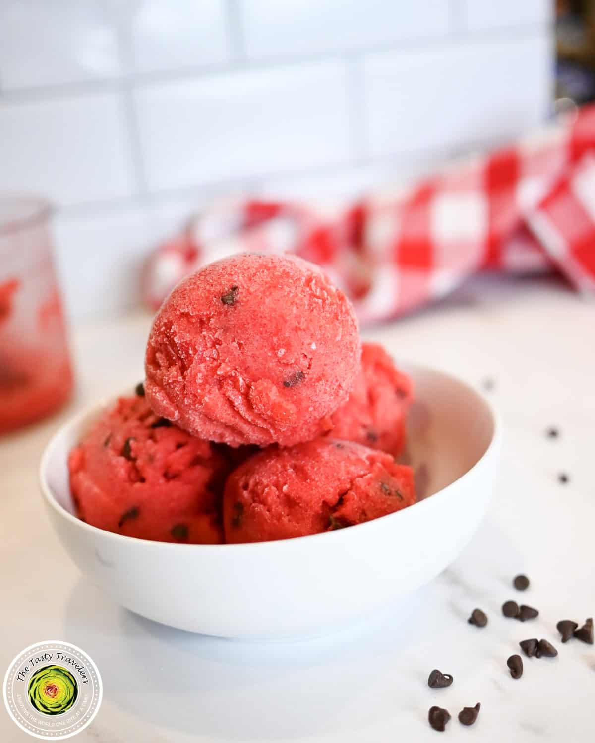 Ninja Creami low calorie cherry chocolate chip sorbet in a pint container topped with cherries and chocolate chips