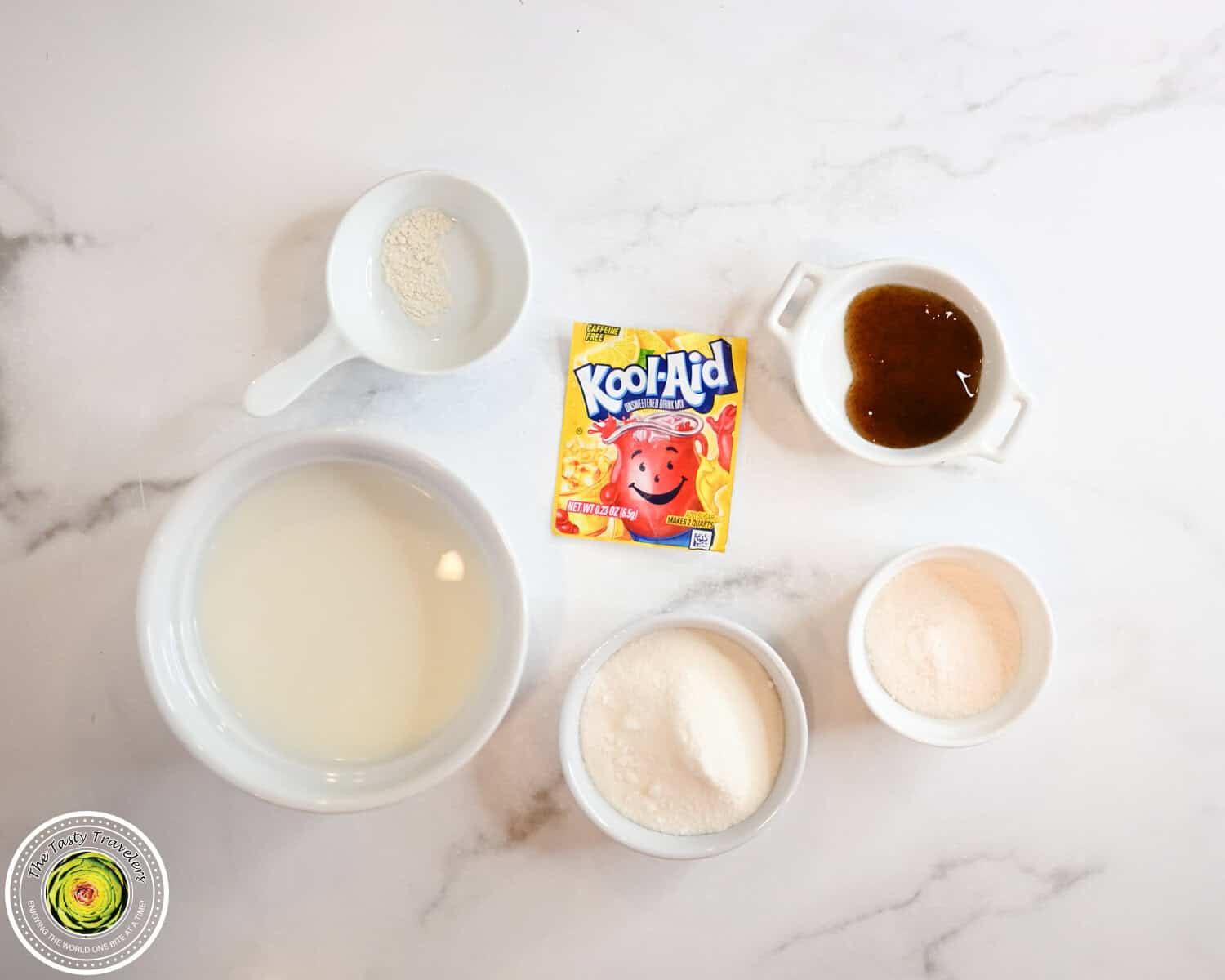 Ingredients for Ninja Creami low calorie frosted lemonade including 2% milk, allulose, sugar free vanilla pudding mix, vanilla bean paste, unsweetened lemonade Kool-Aid, and guar gum