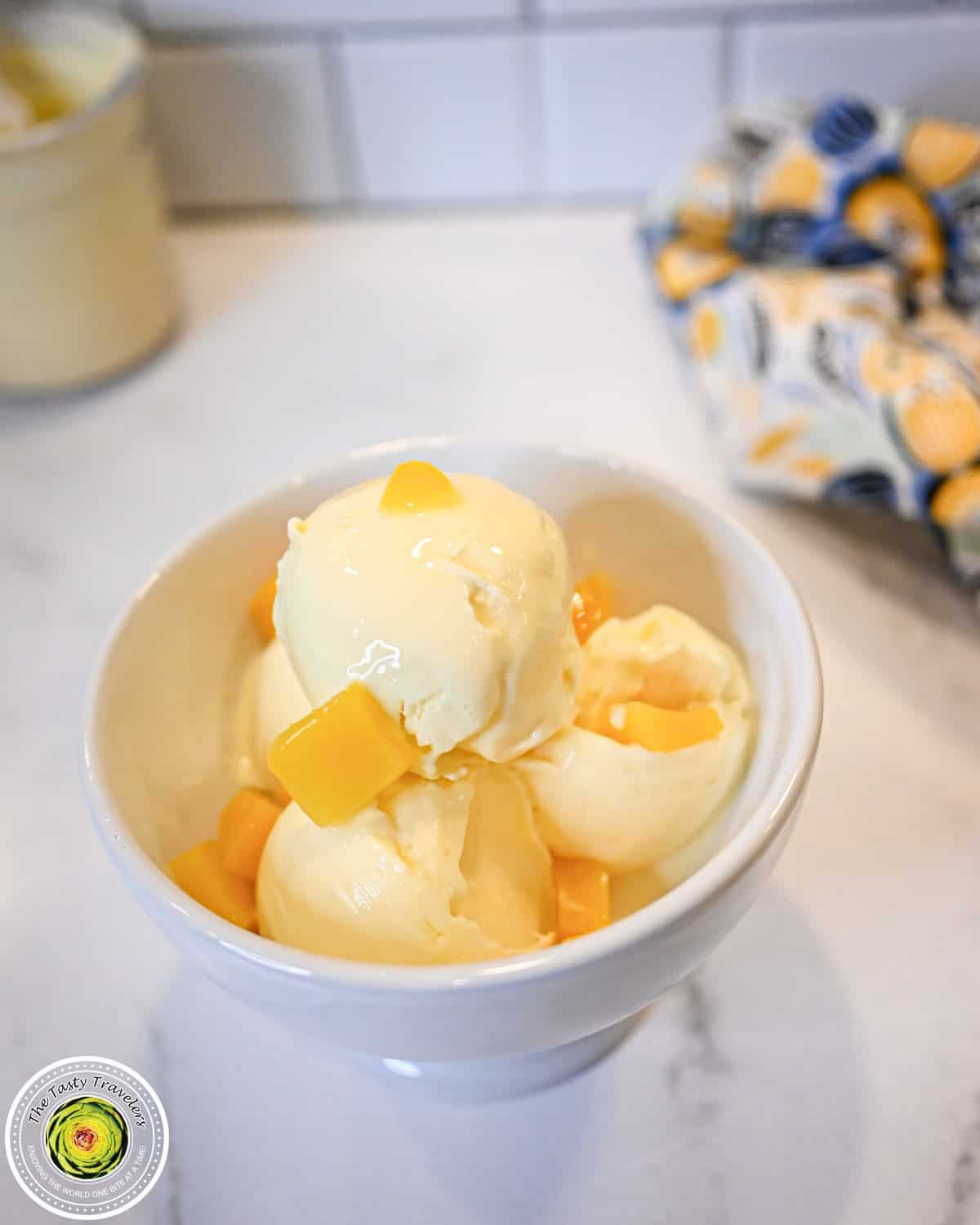 Bowl of Ninja Creami low calorie mango cheesecake ice cream topped with fresh mango pieces