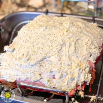 Raw turkey covered with herb butter for roasting, ready for oven.
